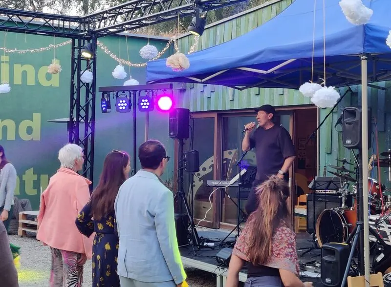 Santiago singt auf der Bühne, Gäste tanzen davor